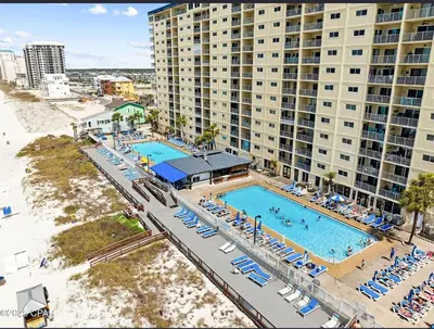 an aerial view of a pool with chairs and buildings at Our Sea Side in Panama City Beach
