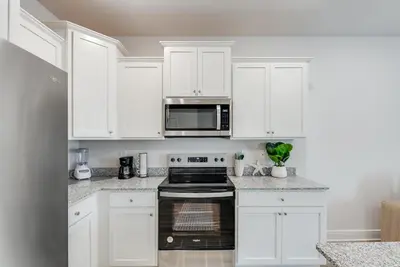a kitchen with white cabinets and a black oven at Bright 3BR Near Beach Vacation House in Panama City Beach