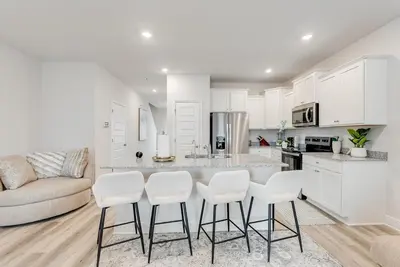 a kitchen with white cabinets and a table and chairs at Bright 3BR Near Beach Vacation House in Panama City Beach