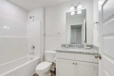 a white bathroom with a toilet and a sink at Bright 3BR Near Beach Vacation House in Panama City Beach