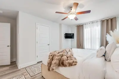 a bedroom with a white bed and a ceiling fan at Bright 3BR Near Beach Vacation House in Panama City Beach