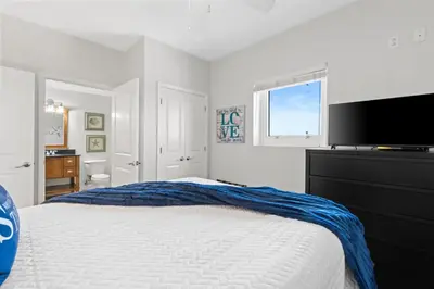 a bedroom with a bed and a flat screen tv at Gulf-View Condo with Pool, Grill, Gym & Beachfront Resort Perks! in Panama City Beach