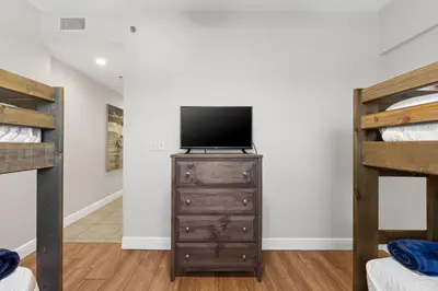 a bedroom with a tv and a dresser with a television at Gulf-View Condo with Pool, Grill, Gym & Beachfront Resort Perks! in Panama City Beach