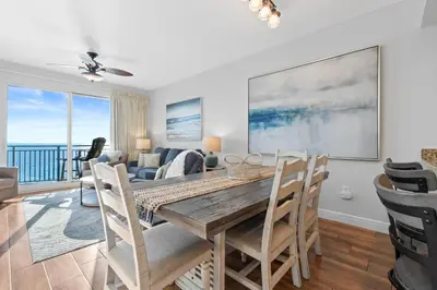 a dining room and living room with a table and chairs at Gulf-View Condo with Pool, Grill, Gym & Beachfront Resort Perks! in Panama City Beach