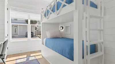a bedroom with a bunk bed in a white room at Spacious Coastal Retreat Near Inlet Beach with Bikes Balconies Modern Design Bluewater View by Avantstay in Inlet Beach
