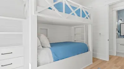 a white bedroom with a bunk bed in it at Spacious Coastal Retreat Near Inlet Beach with Bikes Balconies Modern Design Bluewater View by Avantstay in Inlet Beach