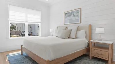 a white bedroom with a large bed and a window at Spacious Coastal Retreat Near Inlet Beach with Bikes Balconies Modern Design Bluewater View by Avantstay in Inlet Beach