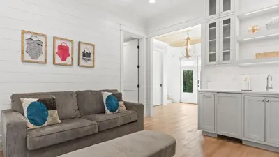 a living room with a couch and a kitchen at Spacious Coastal Retreat Near Inlet Beach with Bikes Balconies Modern Design Bluewater View by Avantstay in Inlet Beach