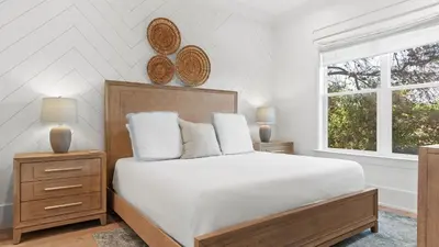 a white bedroom with a bed and a window at Spacious Coastal Retreat Near Inlet Beach with Bikes Balconies Modern Design Bluewater View by Avantstay in Inlet Beach
