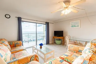 a living room with two couches and a glass table at The Summit 618 - Bright Waterfront Condo in Panama City Beach