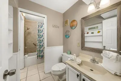 a bathroom with a toilet and a sink and a mirror at The Summit 1023 - Gulf Front Condo in Panama City Beach