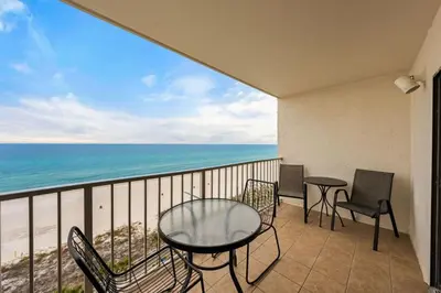 a balcony with a table and chairs and the ocean at The Summit 1023 - Gulf Front Condo in Panama City Beach