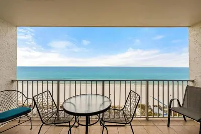 a balcony with a table and chairs and the ocean at The Summit 1023 - Gulf Front Condo in Panama City Beach
