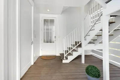 a hallway with white stairs and a white door at Gulf & Lake Views, 6 BR, Pool & 2 minute walk to the beach! in Santa Rosa Beach