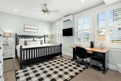 a bedroom with a bed and a desk and windows at Gulf & Lake Views, 6 BR, Pool & 2 minute walk to the beach! in Santa Rosa Beach