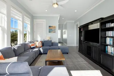 a living room with a blue couch and a tv at Gulf & Lake Views, 6 BR, Pool & 2 minute walk to the beach! in Santa Rosa Beach