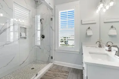 a white bathroom with a shower and a sink at Gulf & Lake Views, 6 BR, Pool & 2 minute walk to the beach! in Santa Rosa Beach