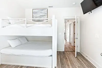 a white bunk bed in a white room at Our Seaside 4 BR Seagrove, HEATED Pool, bikes and 5 min to the beach in Santa Rosa Beach