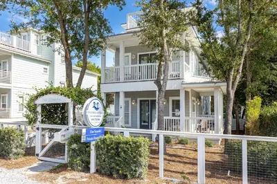 a white house with a sign in front of it at Our Seaside 4 BR Seagrove, HEATED Pool, bikes and 5 min to the beach in Santa Rosa Beach