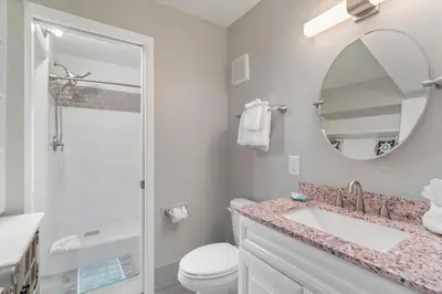 a bathroom with a sink and a toilet and a mirror at The Summit 529 - Newly Remolded Beachfront Condo in Panama City Beach