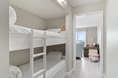 two bunk beds in a room with a mirror at The Summit 529 - Newly Remolded Beachfront Condo in Panama City Beach