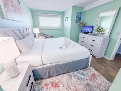 a bedroom with a large white bed and a mirror at The Summit 524 in Panama City Beach