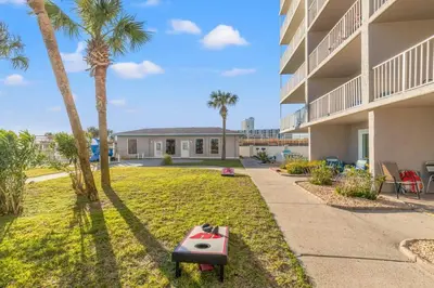 a backyard with palm trees next to a building at The Summit 524 in Panama City Beach
