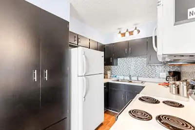 a kitchen with black cabinets and a white refrigerator at The Summit 524 in Panama City Beach