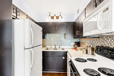 a kitchen with black cabinets and a white refrigerator at The Summit 524 in Panama City Beach