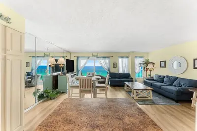 a living room with a blue couch and a table at The Summit 1502 - Family Getaway & Beach Chairs in Panama City Beach