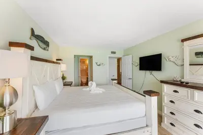 a bedroom with a large white bed and a television at The Summit 1502 - Family Getaway & Beach Chairs in Panama City Beach