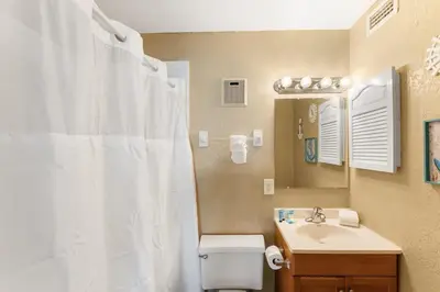 a bathroom with a white shower curtain and a sink at The Summit 1502 - Family Getaway & Beach Chairs in Panama City Beach