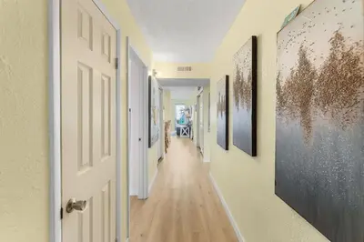 an empty hallway with a door and paintings on the walls at The Summit 1502 - Family Getaway & Beach Chairs in Panama City Beach
