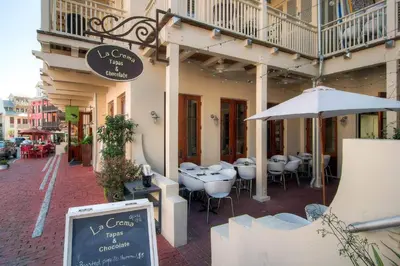 a restaurant with tables and an umbrella on a street at Beachwood Villas 1G - The Nest at Seagrove in Santa Rosa Beach