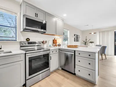 a kitchen with white cabinets and stainless steel appliances at Beachwood Villas 1G - The Nest at Seagrove in Santa Rosa Beach