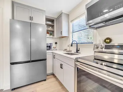 a kitchen with white cabinets and a stainless steel refrigerator at Beachwood Villas 1G - The Nest at Seagrove in Santa Rosa Beach