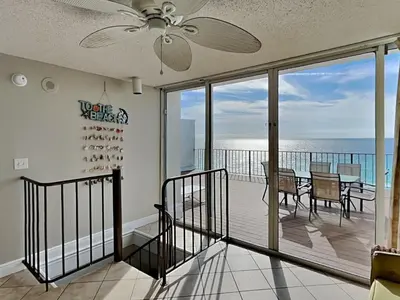 a dining room with a balcony with a view of the ocean at Edgewater Tower I #1203 in Panama City Beach
