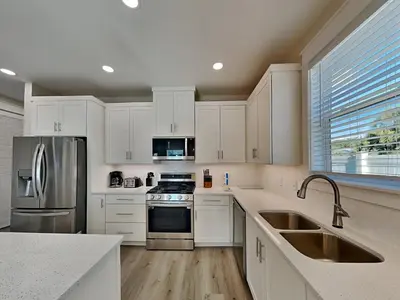 a kitchen with white cabinets and stainless steel appliances at Horizon Dreams A in Panama City Beach