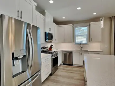 a kitchen with white cabinets and a stainless steel refrigerator at Horizon Dreams A in Panama City Beach