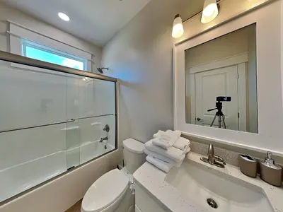 a bathroom with a toilet and a sink and a mirror at Horizon Dreams A in Panama City Beach