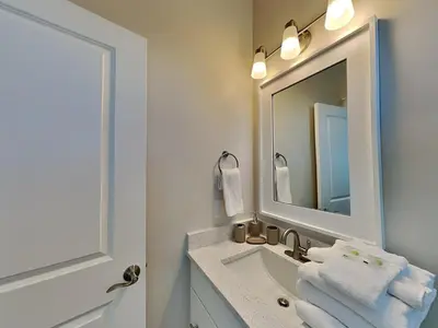 a white bathroom with a sink and a mirror at Horizon Dreams B in Panama City Beach
