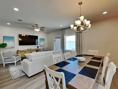 a dining room and living room with a table and a couch at Horizon Dreams B in Panama City Beach
