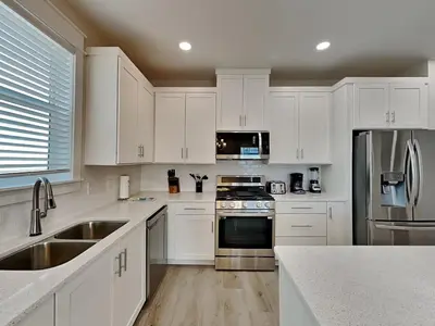 a kitchen with white cabinets and stainless steel appliances at Horizon Dreams B in Panama City Beach