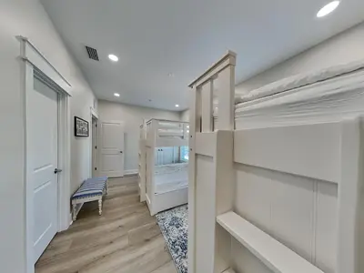 a room with two bunk beds and a hallway at Horizon Dreams in Panama City Beach