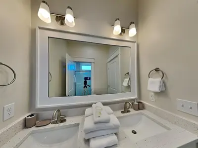 a bathroom with a sink with a large mirror at Horizon Dreams in Panama City Beach