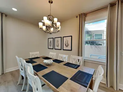 a dining room with a table and chairs and a chandelier at Horizon Dreams in Panama City Beach