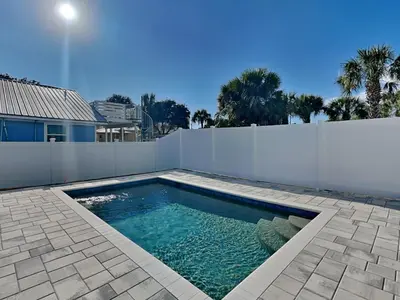 a swimming pool in front of a white fence at Horizon Dreams in Panama City Beach