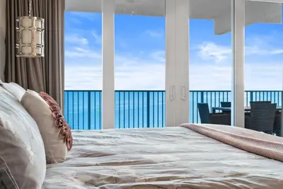a bedroom with a bed with a view of the ocean at Luxe Glam 3BD Retreat! Gulf View Family Resort! in Panama City Beach
