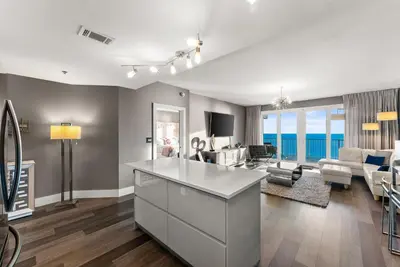 a kitchen and living room with a view of the ocean at Luxe Glam 3BD Retreat! Gulf View Family Resort! in Panama City Beach