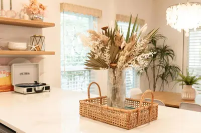 a wicker basket with a vase of flowers on a kitchen counter at Glory Days 30A - Pool, Bikes & Close Beach Access in Inlet Beach